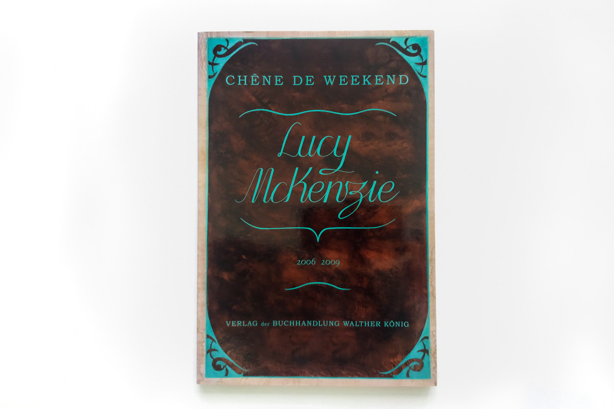 Front cover of Lucy McKenzie's book, shiny brown cover with teal text and decoration