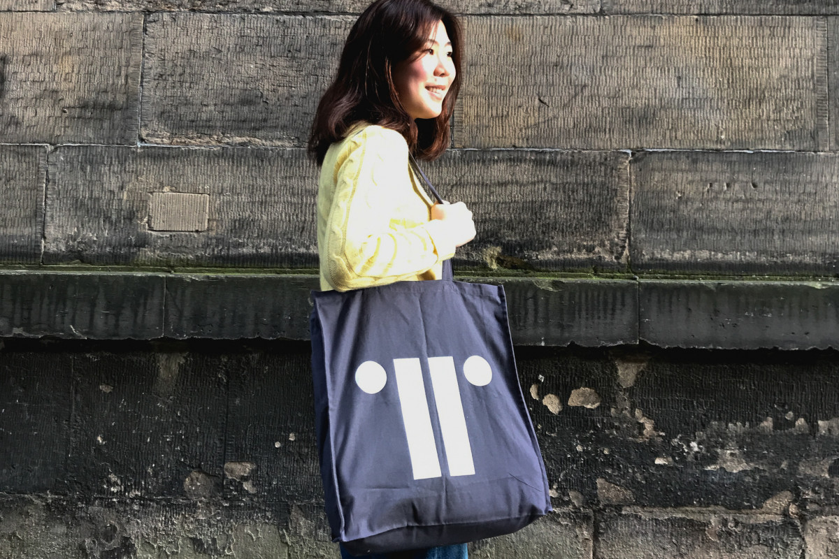Person wearing bag against old stone wall