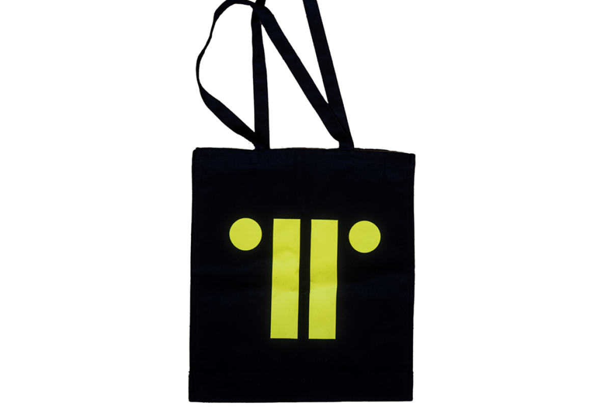 Black canvas bag with bright yellow print of TRG logo against white background.