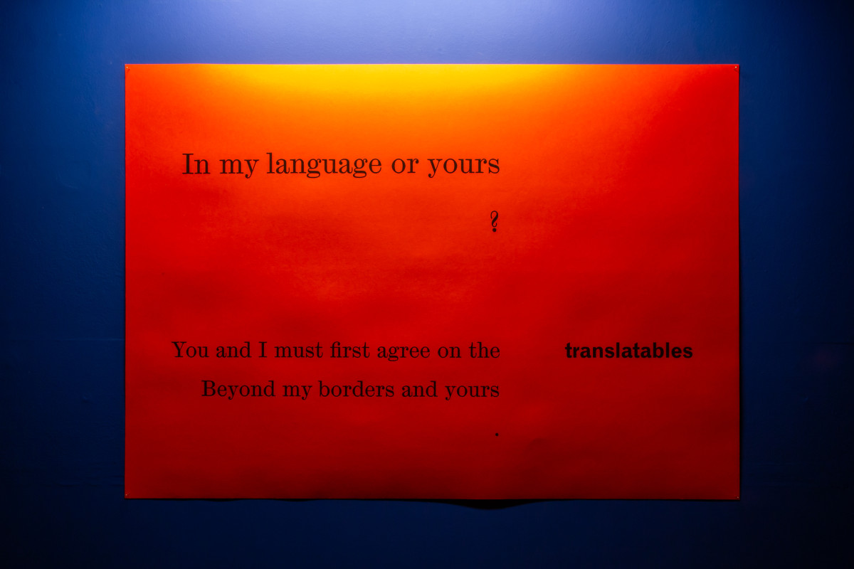 "In my language of yours?" red poster on blue wall
