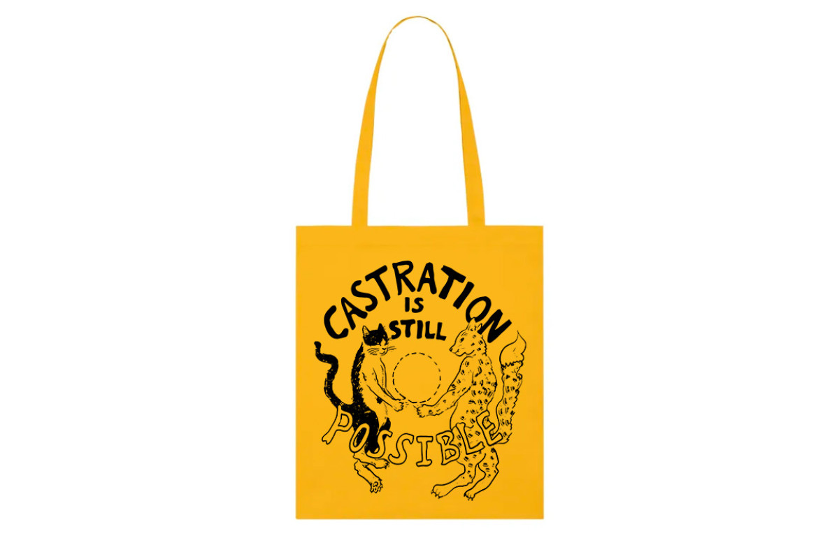 Yellow cotton tote bag with black print design of two cats, and the words 'castration is still possible' on it