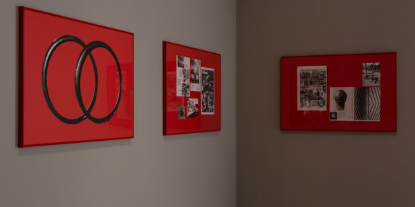 Install image of 3 red screenprints by Celine Condorelli